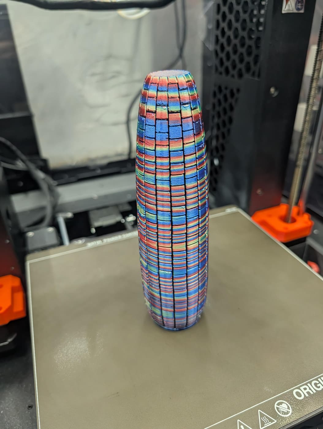 A colorful, textured, corn-like 3D printed object on a build plate