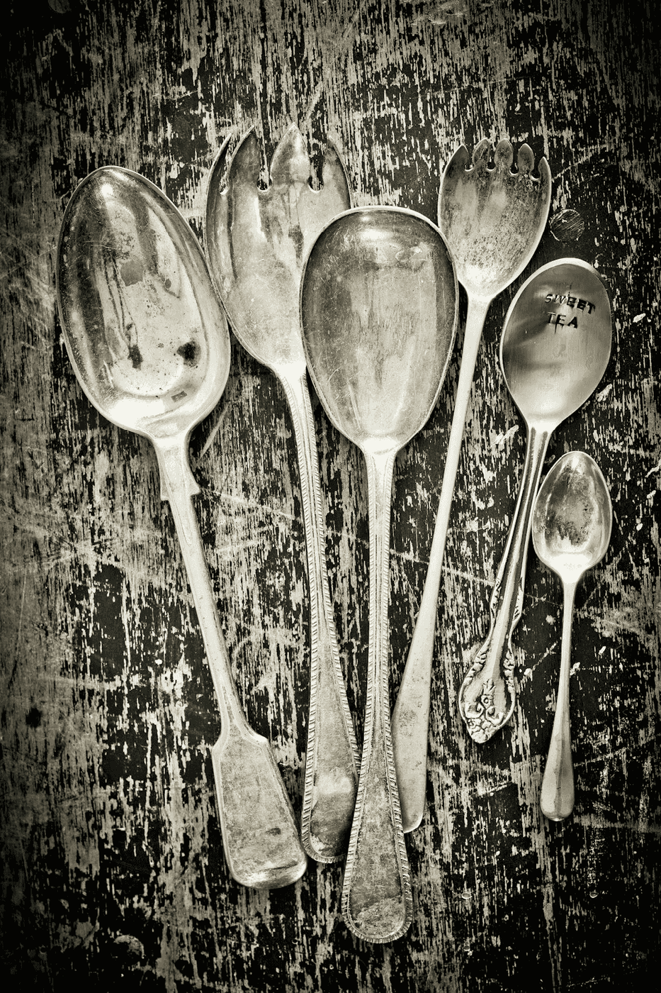 Vintage silver spoon and fork on a dark rustic wooden table